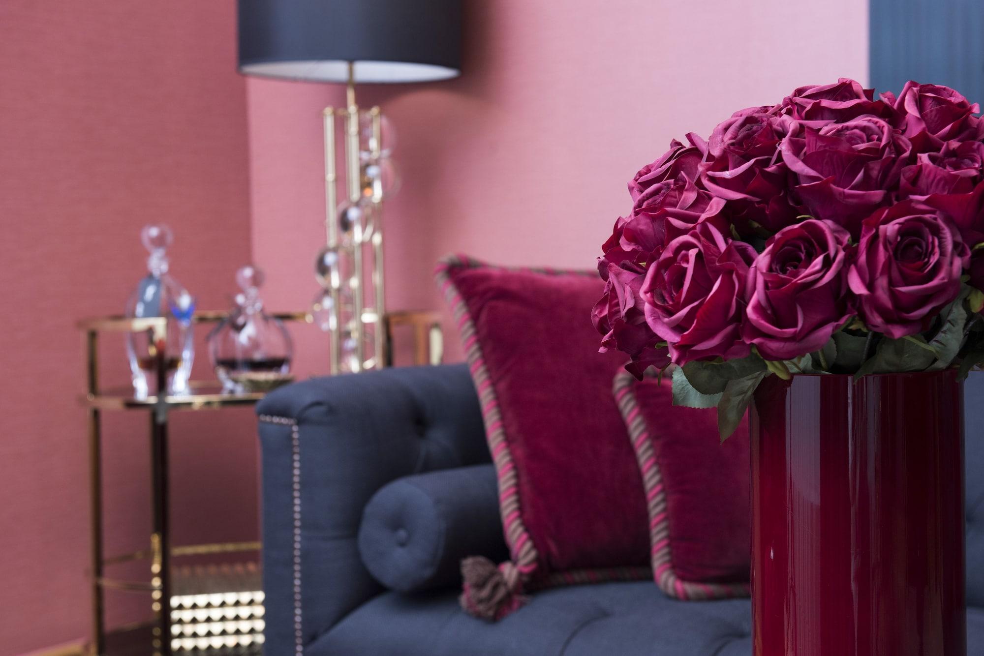 โรงแรมพาเลซ เบอร์ลิน ภายนอก รูปภาพ A living room with a dark blue sofa and a red vase